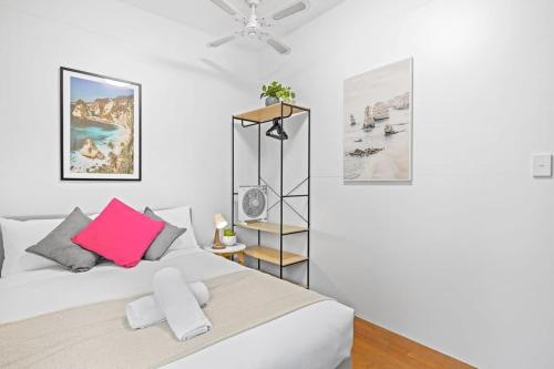 a bedroom with a white bed with a pink pillow at Private Room in Gordon near Train & Bus - Sleeps 1 in Pymble