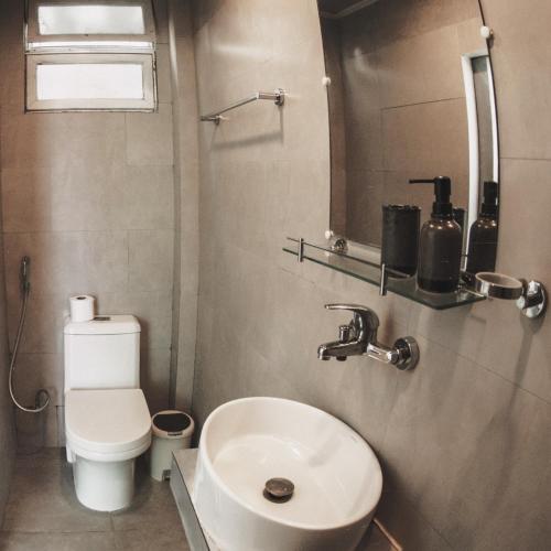 a small bathroom with a toilet and a sink at TWIN PALMS 'Surfhouse' in Thulusdhoo