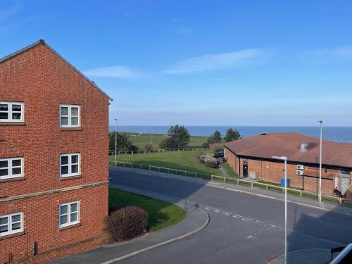 an empty street next to a red brick building at Seaham Sea View 2 bedroom apartment in Seaham