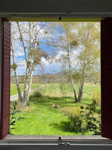 a window with a view of a field with trees at Villa Nid d'Oiseaux in Lustar