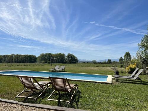 two chairs and a swimming pool in a field at Villa Nid d'Oiseaux in Lustar