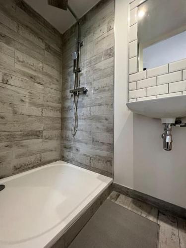 a bathroom with a bath tub and a sink at Villa Nid d'Oiseaux in Lustar