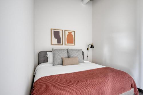 a white bedroom with a bed with a red blanket at Blueground West Loop gym roof nr Union Park CHI-1050 in Chicago
