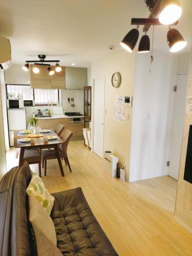 a living room and dining room with a table and a kitchen at 15min to Haneda Airport - Homies House Kamata for up to 9 guests in Tokyo