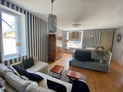 ein Wohnzimmer mit einem Sofa und einem TV in der Unterkunft Donvillaise 15 pers : jacuzzi, 8 min à pied plage in Donville-les-Bains