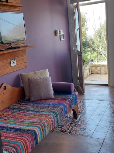 a couch in a room with a tv and a door at Abdelli Terraces in Batroun in Batroûn