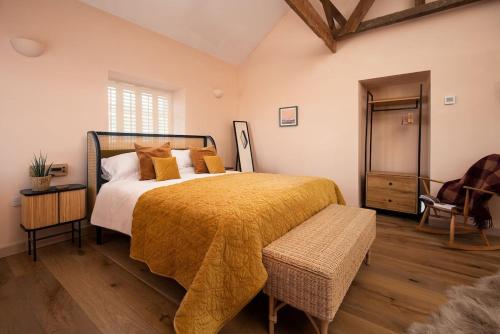 a bedroom with a large bed with a yellow blanket at East Lodge, Home Farm in Belford