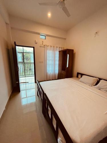 a bedroom with a large bed and a window at EDASSERI ARCADE in Kalpetta