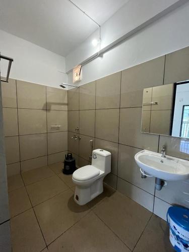 a bathroom with a toilet and a sink at EDASSERI ARCADE in Kalpetta