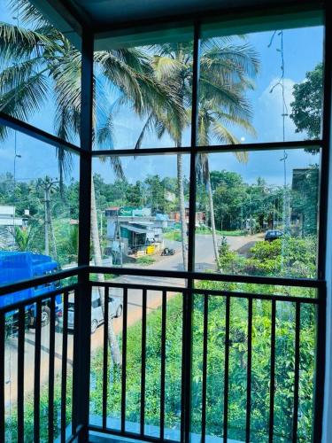 einen Blick aus dem Fenster einer Palme in der Unterkunft EDASSERI ARCADE in Kalpatta