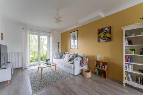 ein Wohnzimmer mit einem Sofa und einem Tisch in der Unterkunft Nice apartment with terrace in Le Bouscat - Welkeys in Le Bouscat