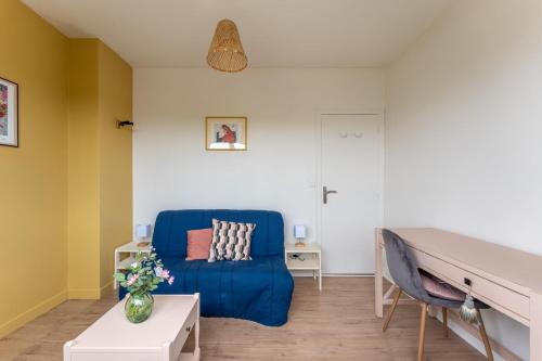 a living room with a blue couch and a table at Appartement Sadi - Welkeys in Le Bouscat