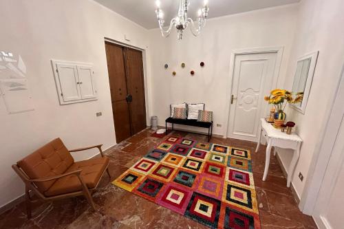 a living room with a chair and a rug on the floor at Calabre - Lamezia Terme 2bdr in Lamezia Terme