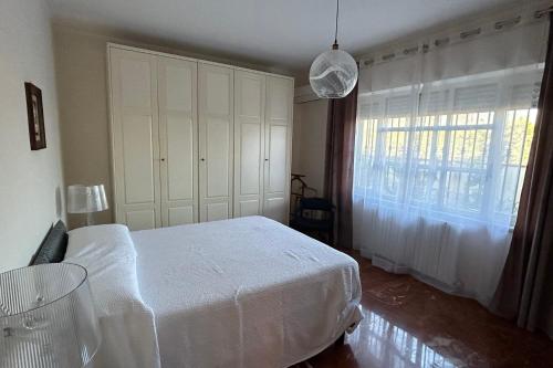 a bedroom with a white bed and a window at Calabre - Lamezia Terme 2bdr in Lamezia Terme