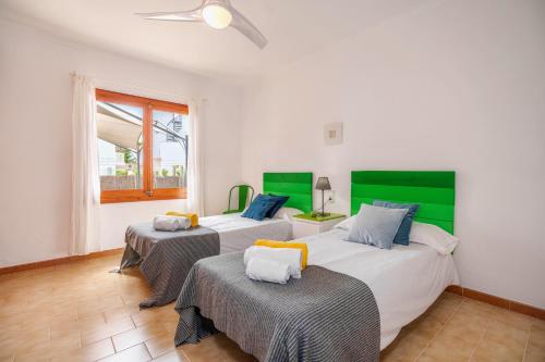 プラヤ・デ・ムロにあるVilla REUS ALCUDIAの緑と白の部屋のベッド2台