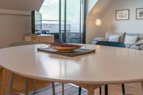 a white table in a living room with a bowl on it at Balcon sur le lac charmant T3 avec vue spectaculaire in Duingt