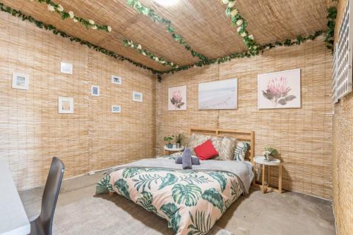 ein Schlafzimmer mit einem Bett in einer Ziegelwand in der Unterkunft Rustic External Private Room in Waterfront Beach Retreat 10 - SHAREHOUSE in Sydney