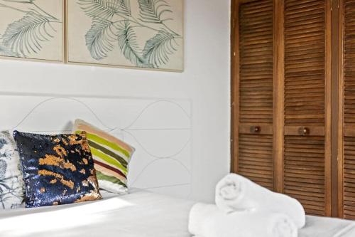 Private Room in Sans Souci Guesthouse في سيدني: سرير أبيض فوقه منشفة