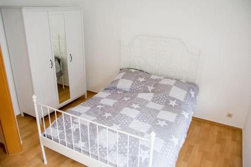 a bedroom with a bed with a gray and white quilt at Schöne 2-Raum-Wohnung im Zentrum Waltershausens in Waltershausen