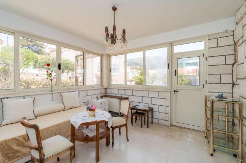 a living room with a couch and a table and chairs at Apartment Begovica in Dubrovnik