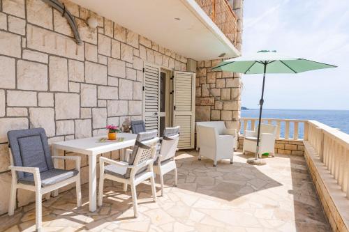 a patio with a table and chairs and an umbrella at Apartment Begovica in Dubrovnik