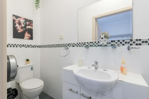 Baño blanco con lavabo y aseo en Boutique Private Suite 7 Min Walk to Sydney Domestic Airport 3- ROOM ONLY en Sídney