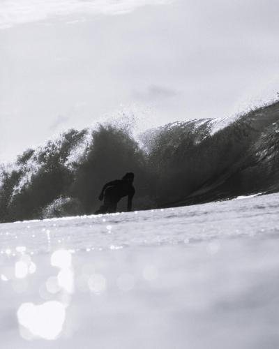 a man riding a wave on a surfboard in the ocean at TWIN PALMS 'Surfhouse' in Thulusdhoo