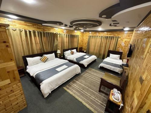 a room with two beds in it with curtains at Signature Skardu Hotel in Skardu