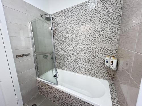 a bathroom with a shower and a white tub at נוף נתניה in Netanya