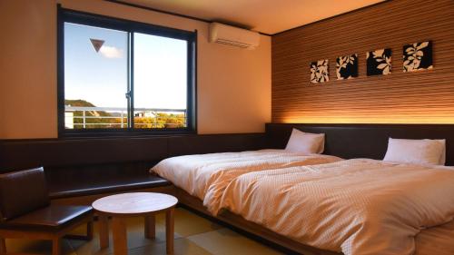 1 dormitorio con 2 camas y ventana en Hotel Yume-no-yu, en Omachi