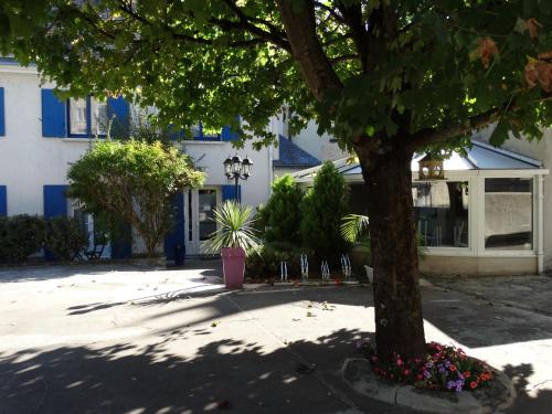 a tree in front of a building with flowers at Castel Fleuri in Tours