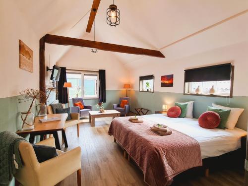een slaapkamer met een bed en een woonkamer bij 2-persoons luxe vakantiewoning in De Veenhoop