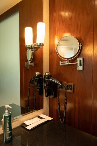 a bathroom with a mirror and a phone on the wall at DoubleTree by Hilton-Pune Chinchwad in Pune