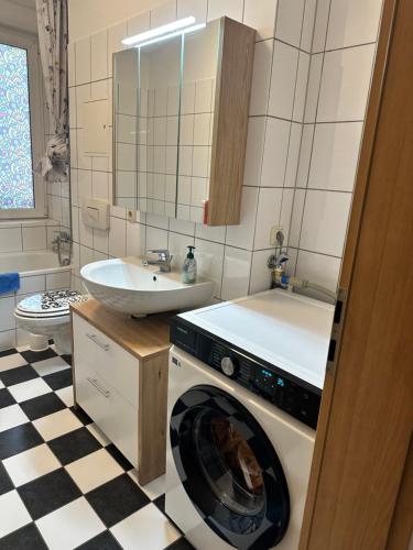 een badkamer met een wasmachine en een wastafel bij Käthe-Kollwitz Straße 54, F1 in Altenburg
