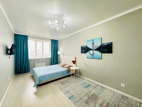 a bedroom with a bed and a painting on the wall at Роза Багланова in Astana