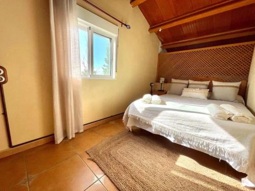 a bedroom with a large bed and a window at Villa Delta in L'Eucaliptus