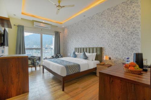 una camera con letto e tavolo con televisore di Levelup Plus Pinaaki Inn a Rishikesh