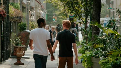 two men walking down a street holding hands at Loews Philadelphia Hotel in Philadelphia