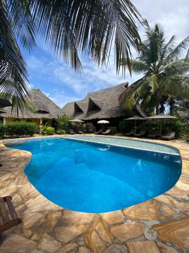 - une piscine en face d'une maison dans l'établissement Kiwengwa Bungalow Boutique Resort, à Kiwengwa