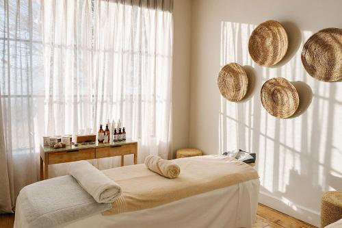 a bedroom with a bed and straw hats on the wall at Elephant lodge in Kwa Kuchinia