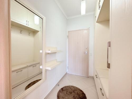 une salle de bain blanche avec un miroir et un lavabo dans l'établissement Tirana Family Suite, à Kashari