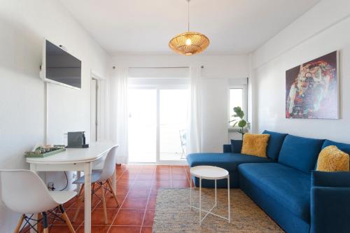 a living room with a blue couch and a desk at Beach House Cascais Close to Lisbon & Sintra in Estoril