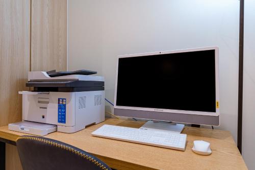 a desk with a computer monitor and a printer at Browndot Samcheonpo in Sacheon