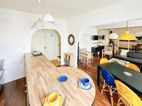 een woonkamer en eetkamer met een houten tafel bij Spacieux appartement en centre-ville des Sables - 6 pers in Les Sables-dʼOlonne