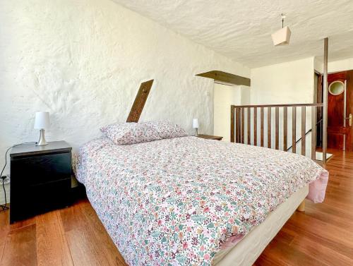 een slaapkamer met een bed met een bloemdekbed bij Spacieux appartement en centre-ville des Sables - 6 pers in Les Sables-dʼOlonne