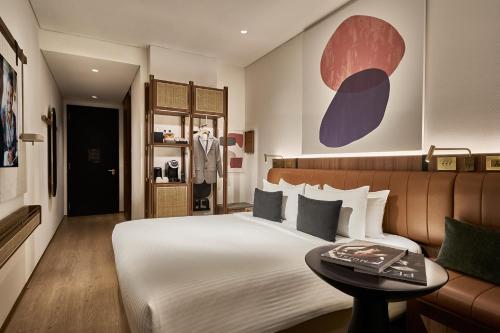 a bedroom with a large bed and a table at Citadines Connect City Centre Singapore in Singapore