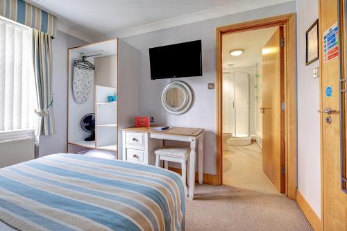 a bedroom with a bed and a desk and a television at The Derby Conference Centre and Hotel in Derby