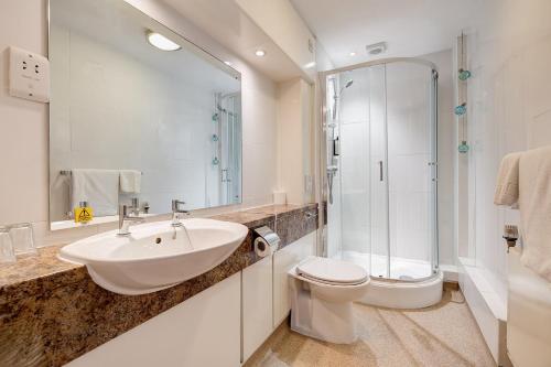 uma casa de banho com um lavatório, um WC e um chuveiro em The Derby Conference Centre and Hotel em Derby