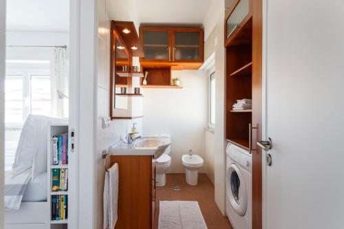 a small bathroom with a sink and a toilet at Beach House Cascais in Estoril