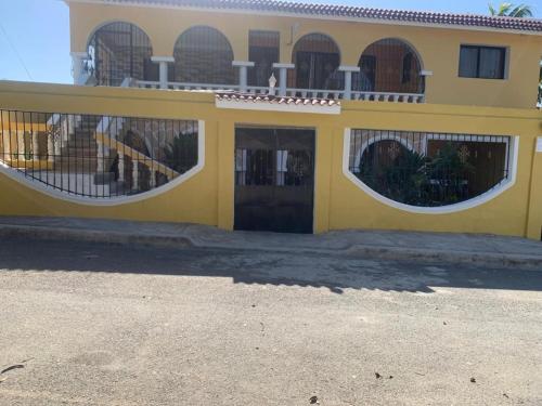 a yellow building with two windows and a balcony at Casa Francesca in Boca Chica